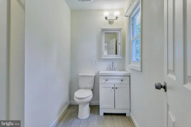 a bathroom with a toilet a sink and mirror