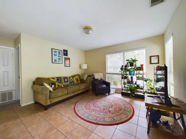 a living room with furniture a rug and a window