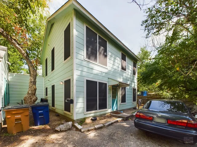 a view of backyard with wooden fence and large trees