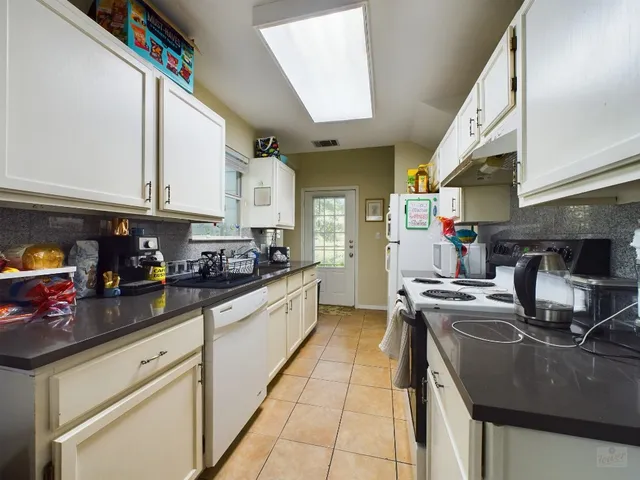 a kitchen with a sink a stove and cabinets