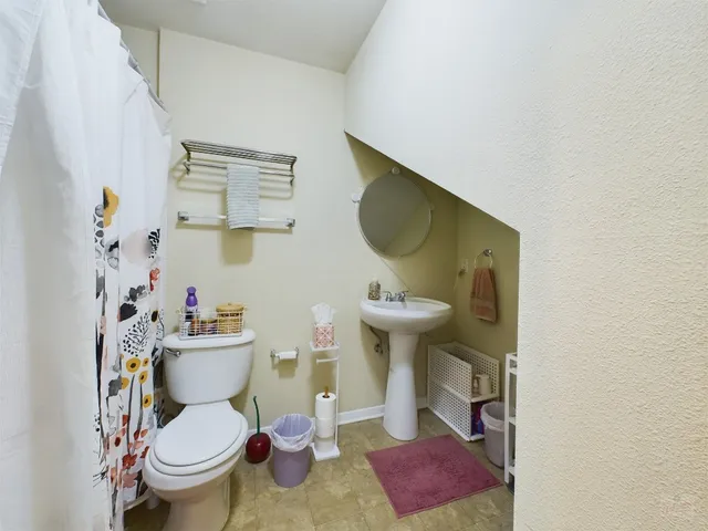 a bathroom with a toilet sink and mirror