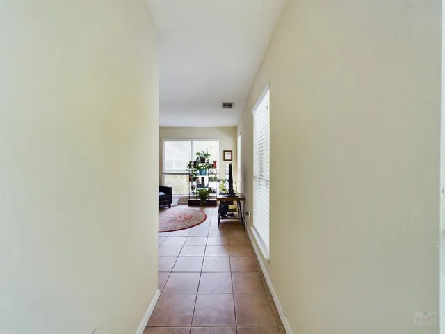 a hallway with a dining room and mirror