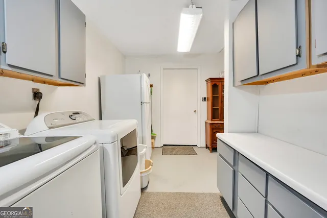 a utility room with cabinets washer and dryer