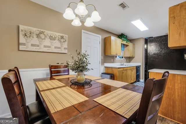 a view of a dining room with furniture and chandelier