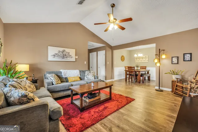 a living room with furniture kitchen view and a large window