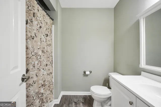 a white toilet sitting next to a shower curtain