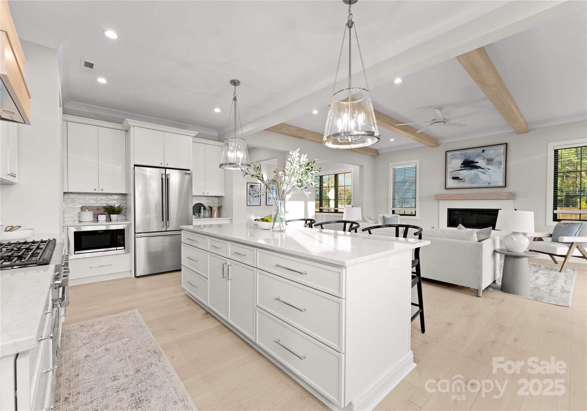 19405 Coachmans Trace Cornelius, NC 28031 - Photo 20 of 44 a large white kitchen with a refrigerator a stove a sink dishwasher a dining table and chairs cabinets
