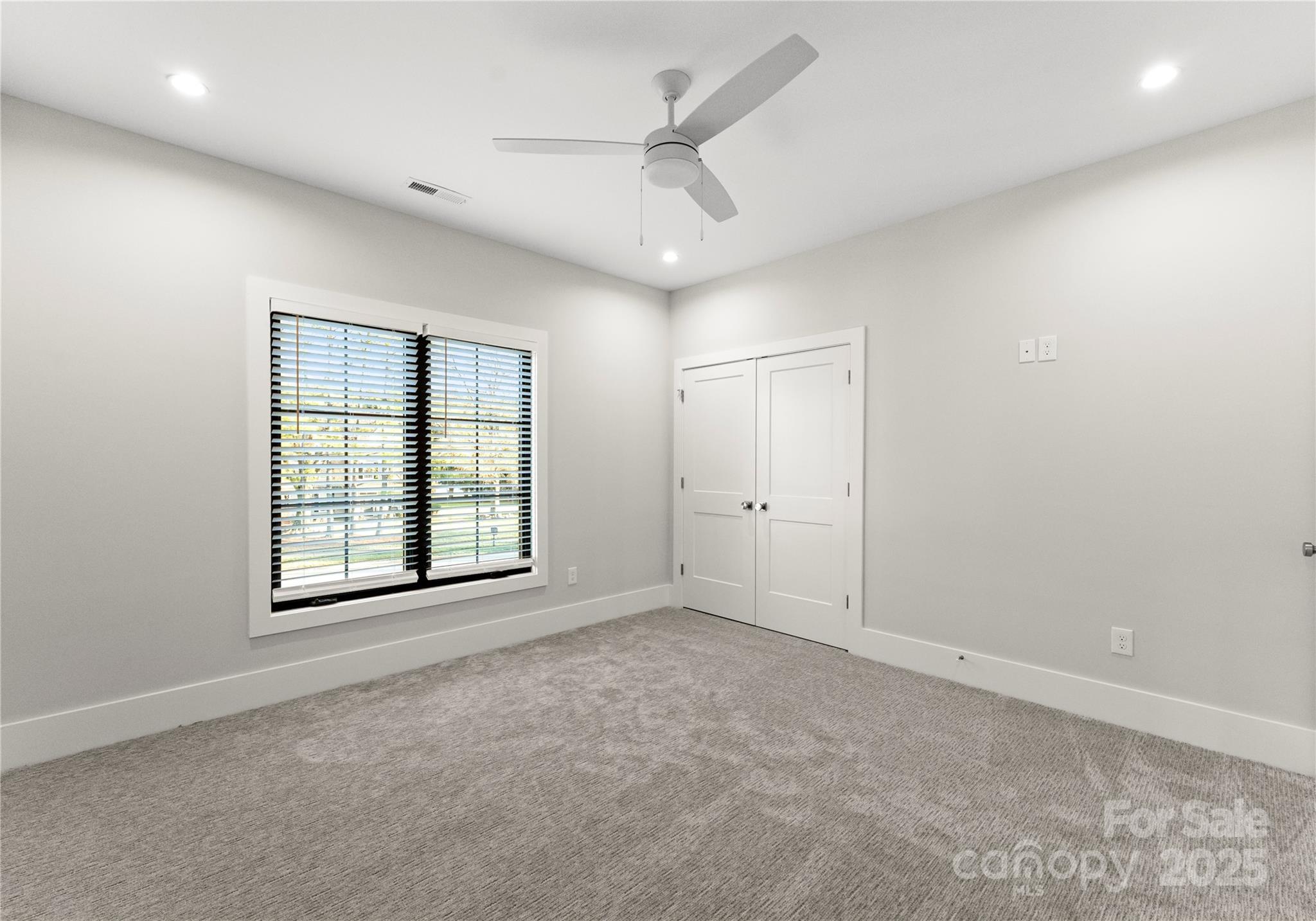 19405 Coachmans Trace Cornelius, NC 28031 - Photo 34 of 44 an empty room with windows and ceiling fan
