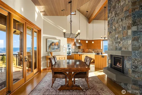 a dining room with furniture a fireplace and wooden floor