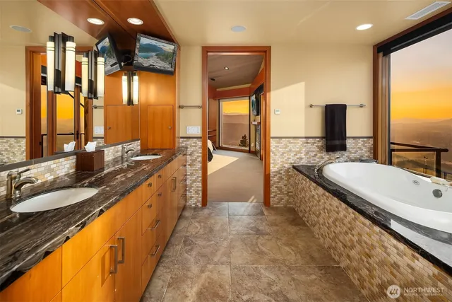 a bathroom with a granite countertop sink and a large mirror