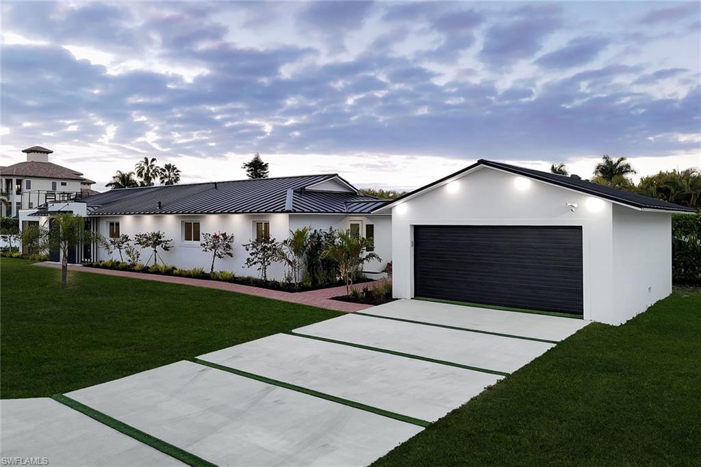 10002 Vanderbilt Drive Naples, FL 34108 - Photo 8 of 42 Concrete driveway with astroturf.