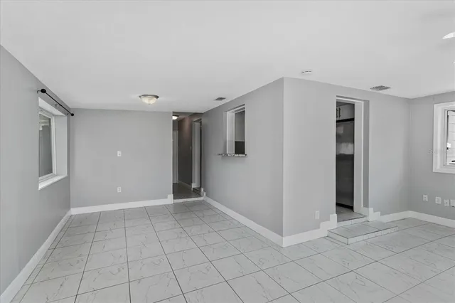 an empty room with fan and windows