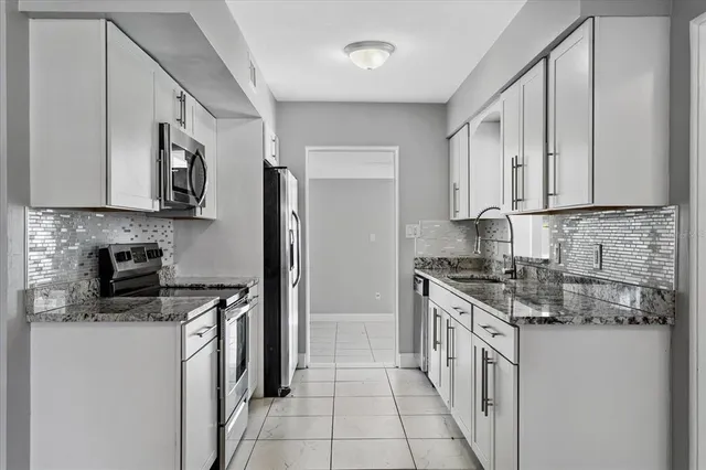 a kitchen with stainless steel appliances granite countertop a sink stove oven and refrigerator
