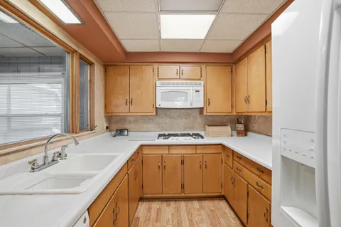 a kitchen with a sink a stove cabinets and a wooden floor