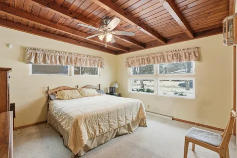 a bedroom with a bed with wooden floor