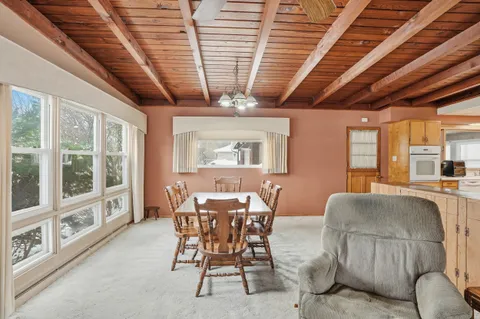 a dining room with furniture a rug and a large window
