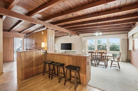 a dining room with furniture window wooden floor and garden view