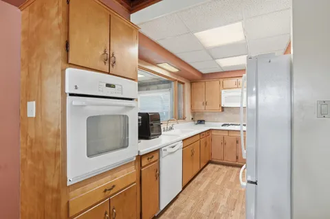 a kitchen with stainless steel appliances white cabinets and wooden floors