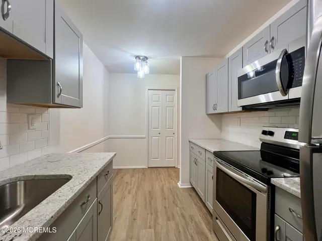 a kitchen with stainless steel appliances granite countertop a sink stove and microwave