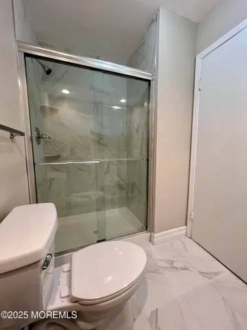 a bathroom with a toilet and a shower