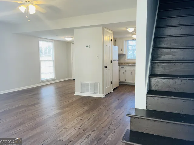 a view of a hallway with wooden floor and staircase