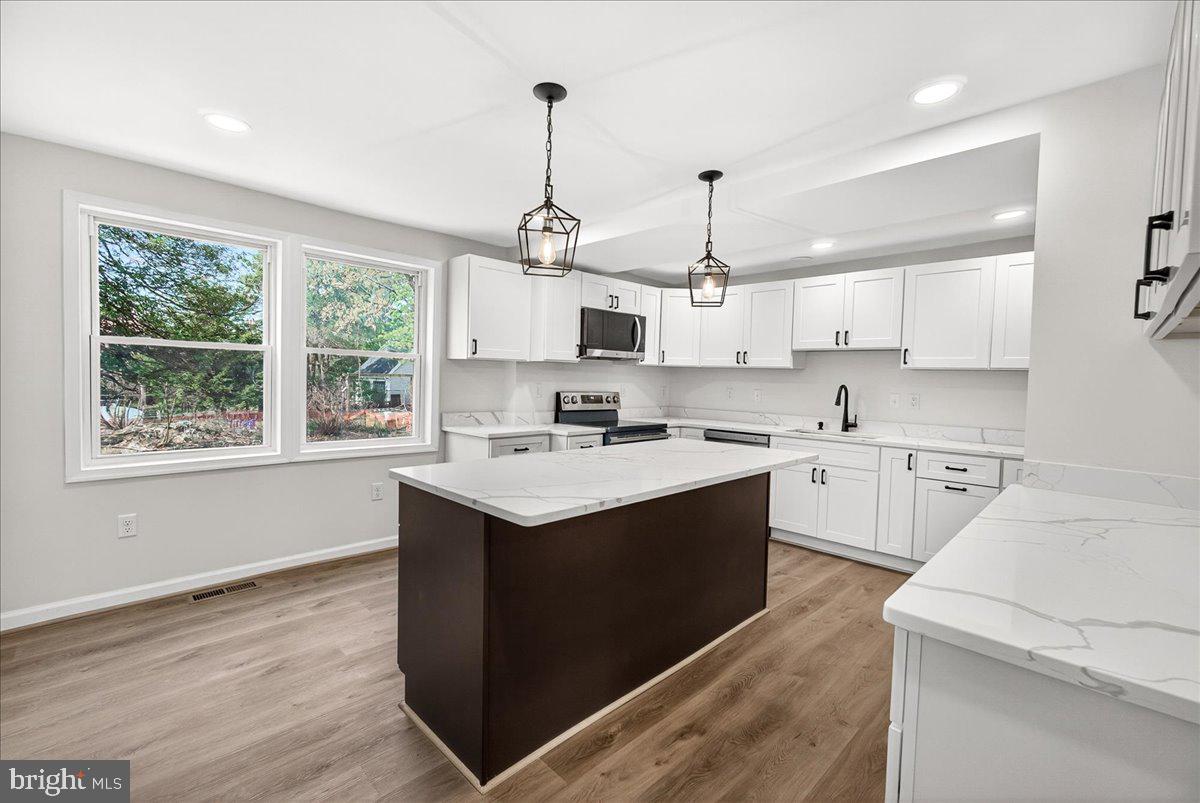 629 Wilson Place Frederick, MD 21702 - Photo 21 of 39 a kitchen with kitchen island granite countertop a sink appliances cabinets and a counter top space