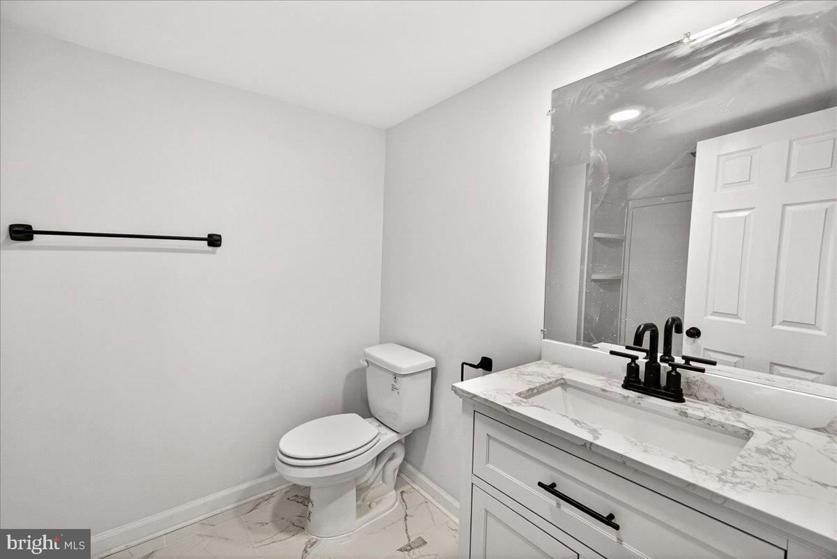 629 Wilson Place Frederick, MD 21702 - Photo 32 of 39 a bathroom with a granite countertop sink toilet and a mirror