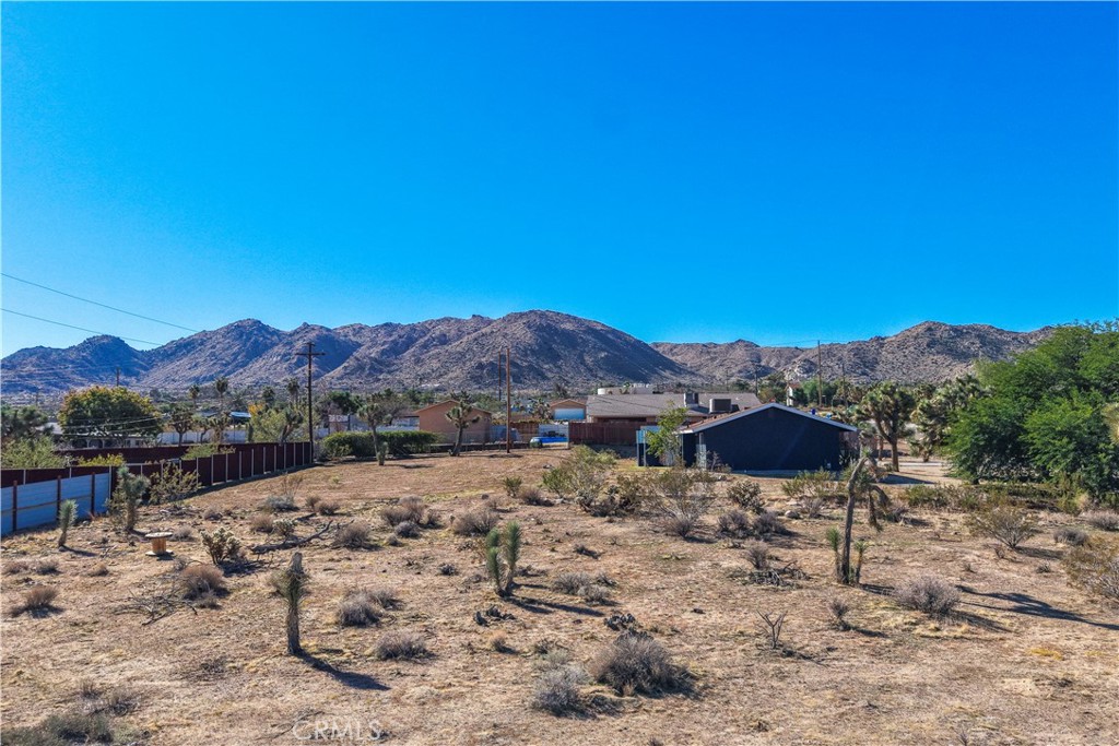 7201 Olympic Road Joshua Tree, CA 92252 - Photo 8 of 12 a view of a backyard with a table and chair under an umbrella