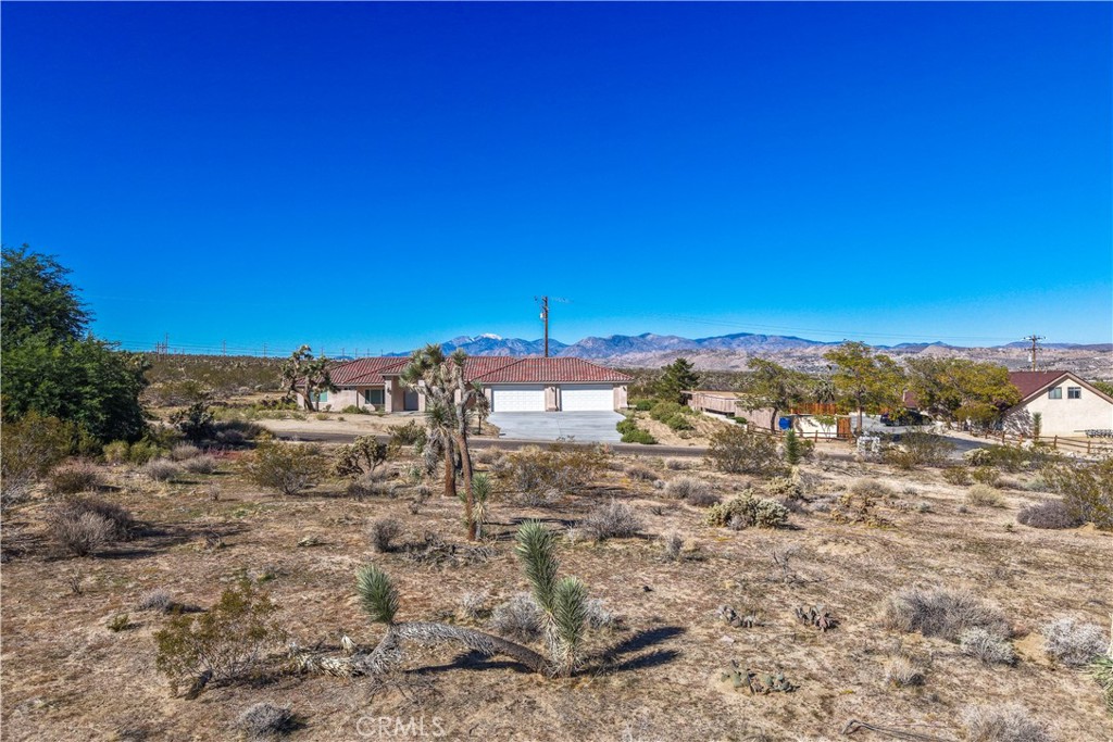 7201 Olympic Road Joshua Tree, CA 92252 - Photo 9 of 12 a view of a building with mountains in the background