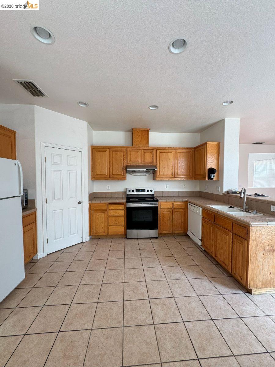 645 Rockspray Circle Pittsburg, CA 94565 - Photo 21 of 31 a large kitchen with a stove a sink dishwasher and a refrigerator