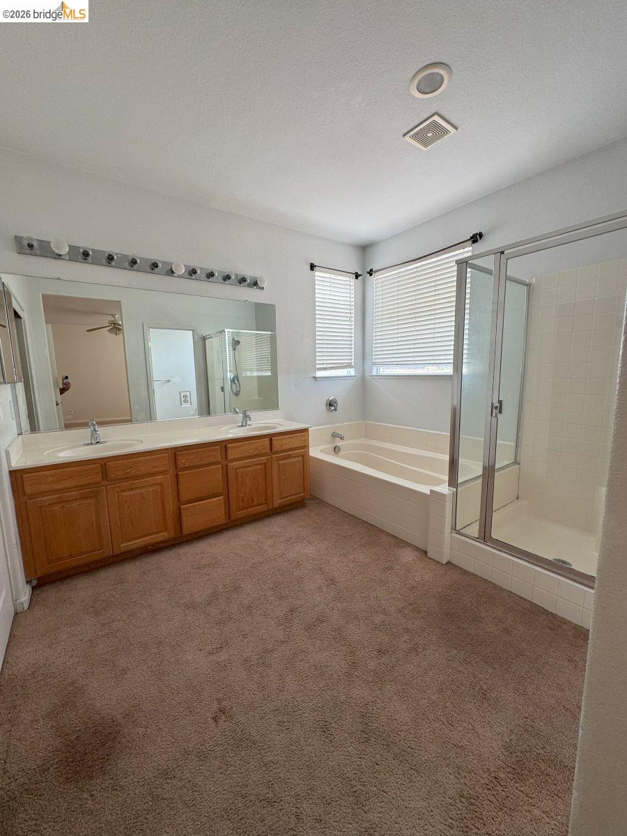 645 Rockspray Circle Pittsburg, CA 94565 - Photo 30 of 31 Bathroom with light colored carpet, a bath, a shower stall, double vanity, and a textured ceiling