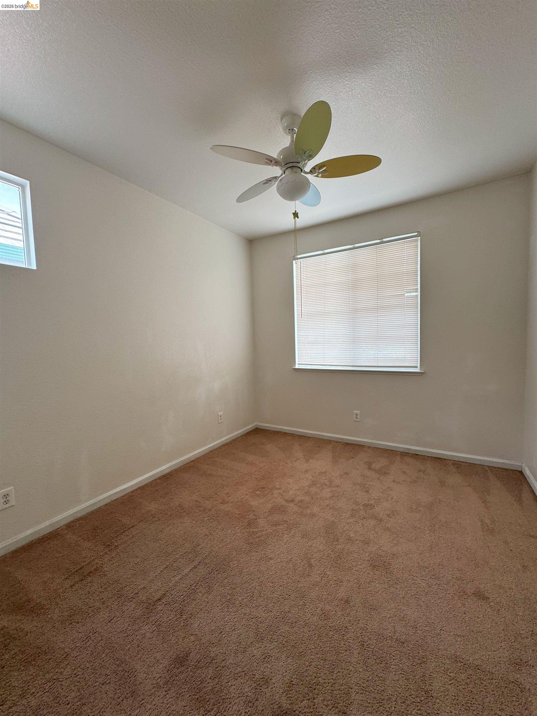 645 Rockspray Circle Pittsburg, CA 94565 - Photo 5 of 31 an empty room with a window and a fan