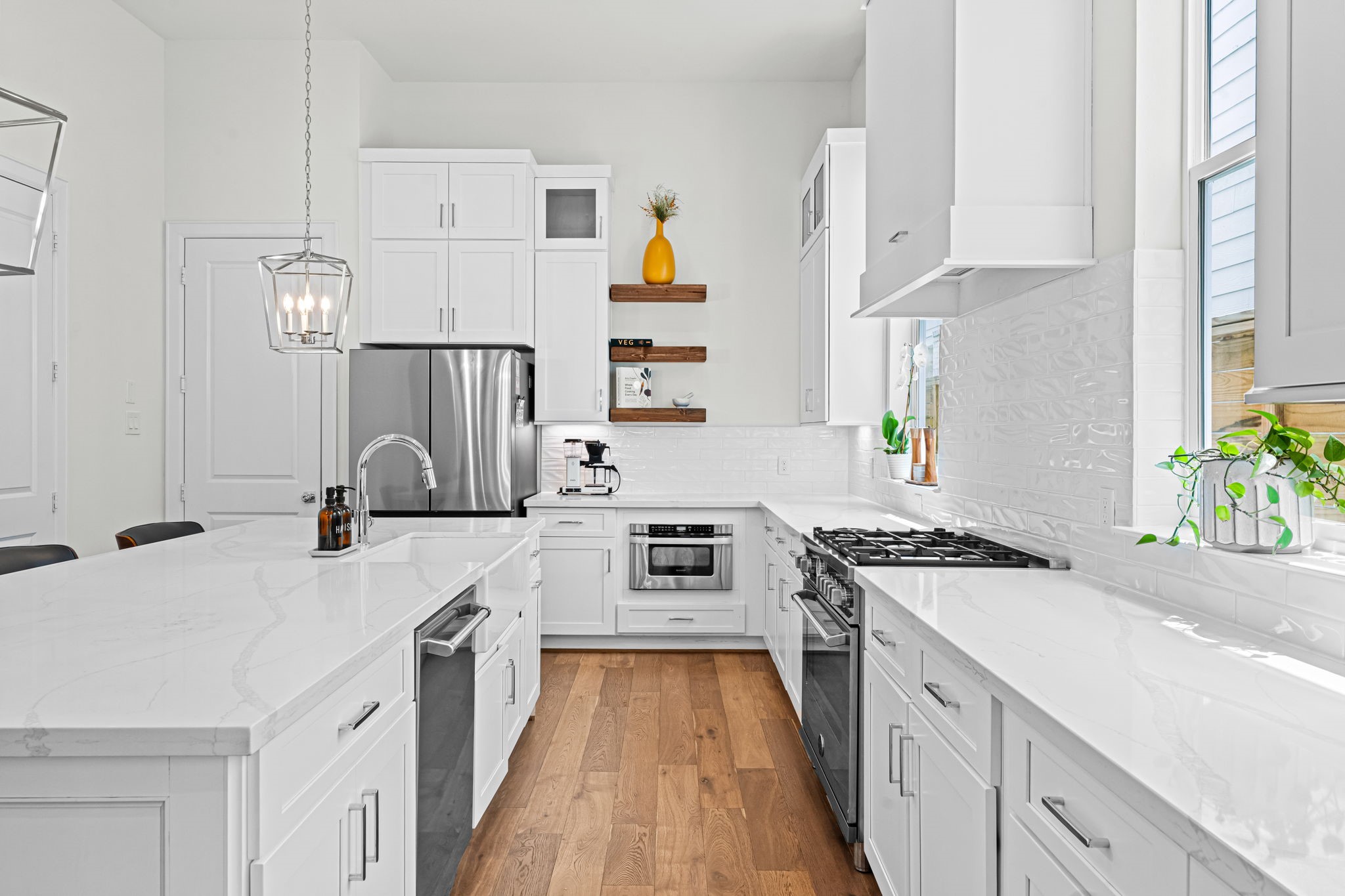 533 West 27th Street Houston, TX 77008 - Photo 3 of 22 Thoughtfully designed kitchen features Bertazzoni stainless steel appliances, quartz countertops, porcelain tile backsplash, floating shelves, and Shaker-style cabinetry with soft-close doors and drawers.