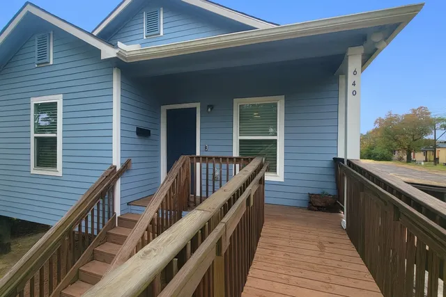 a balcony with wooden floor and stairs