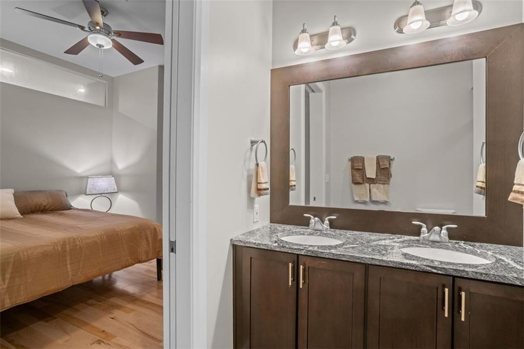301 Fifth Avenue, Unit 606 Pittsburgh, PA 15222 - Photo 14 of 27 a en suite bathroom with a granite countertop sink and a mirror