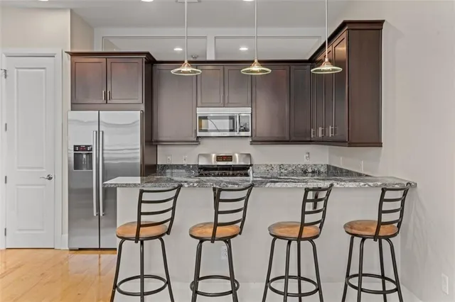 a kitchen with stainless steel appliances granite countertop a stove a refrigerator and a microwave