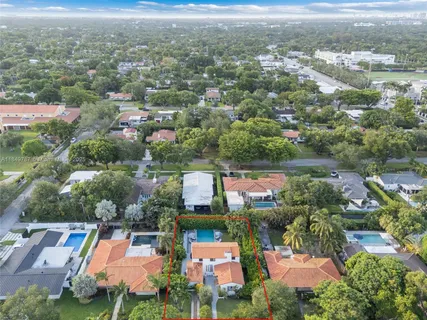 an aerial view of residential houses with outdoor space and lake view