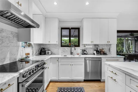 a kitchen with a sink a stove cabinets and a window