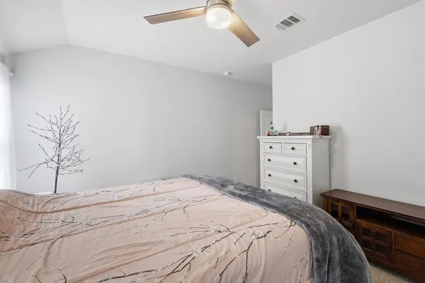 a bedroom with a bed and a potted plant