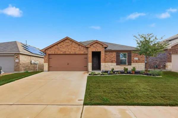 a front view of a house with a garden and yard
