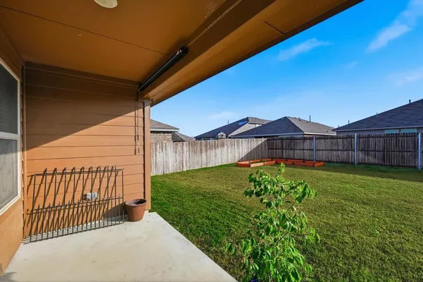 a view of a backyard with wooden fence