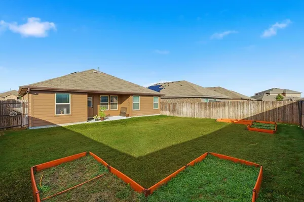 a view of a white house with a big yard and potted plants