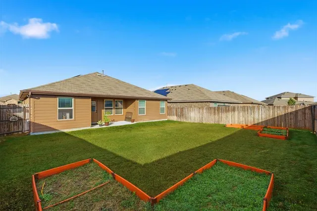 a view of a white house with a big yard and potted plants