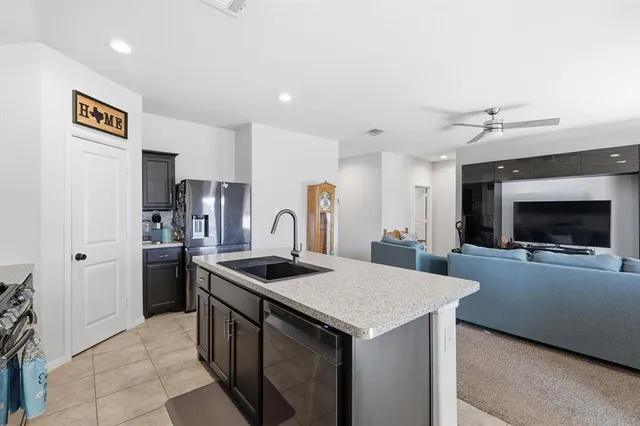 a kitchen with stainless steel appliances granite countertop a sink and a refrigerator