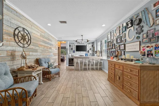 a living room with stainless steel appliances kitchen island granite countertop a sink and a flat screen tv