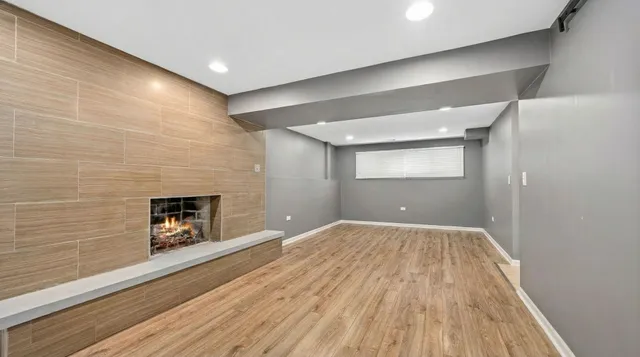 a view of empty room with wooden floor and fireplace