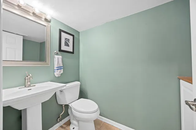 a bathroom with a sink mirror and toilet