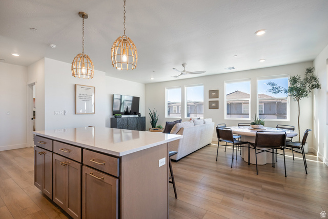 762 West Periwinkle Lane, Unit 102 St. George, UT 84790 - Photo 40 of 40 Kitchen with a center island, open floor plan, light wood-type flooring, decorative light fixtures, and a breakfast bar