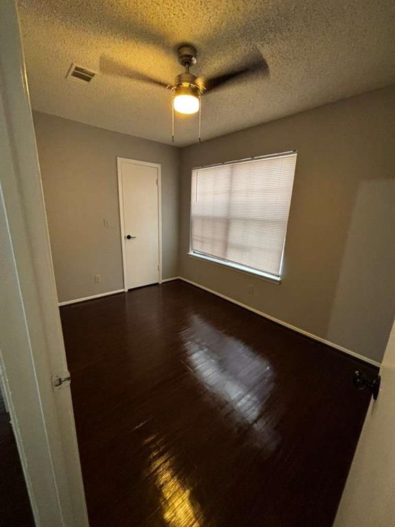 724 West Collins Street Denton, TX 76201 - Photo 3 of 12 an empty room with wooden floor and windows