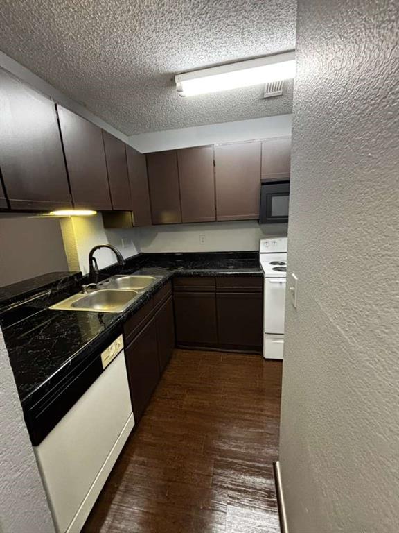 724 West Collins Street Denton, TX 76201 - Photo 5 of 12 a kitchen with stainless steel appliances granite countertop a stove a sink and a microwave